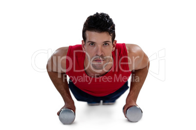 Portrait of determined sports player exercising with dumbbells