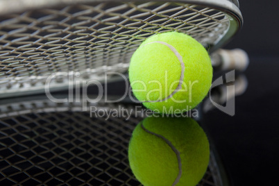 Close up of tennis racket on ball with reflection