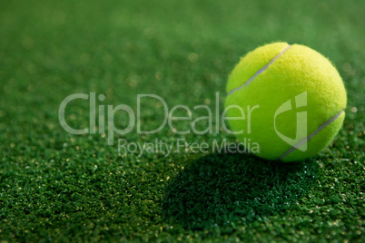 Close up of fluorescent yellow tennis ball on grass