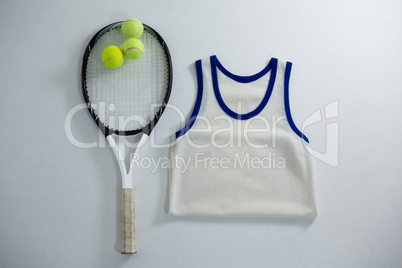 Overhead view of racket with tennis balls by vest