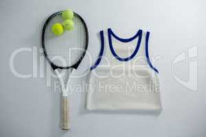Overhead view of racket with tennis balls by vest