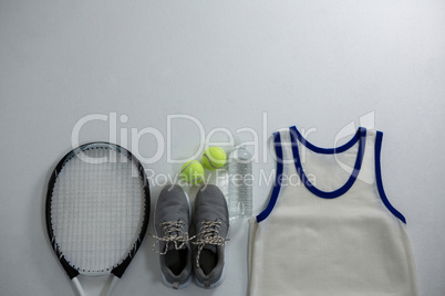 Racket with ball and sports shoe by vest