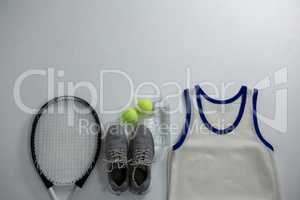 Racket with ball and sports shoe by vest