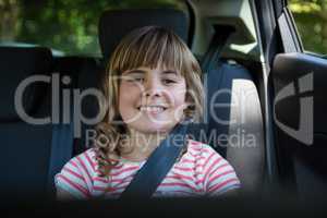 Happy teenage girl sitting in the back seat of car