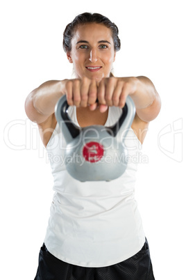 Portrait of young female athlete lifting kettlebell