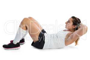 Side view of female athlete practicing sit ups