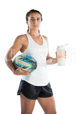 Portrait of female rugby player with ball and drinking bottle