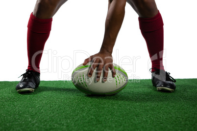 Low section of sportsman with rugby ball