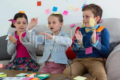 Kids as business executives playing with sticky notes