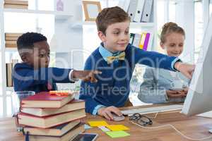 Kids as business executives discussing over desktop pc