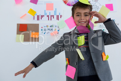 Boy as business executive with sticky notes on his body