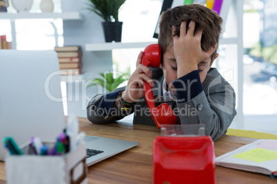 Boy as business executive talking on phone