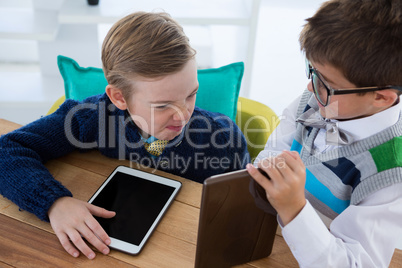 Kids as business executives interacting while using digital tablet