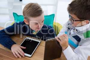 Kids as business executives interacting while using digital tablet