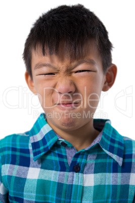 Cute boy making faces against white background