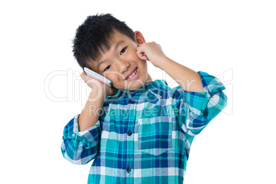 Boy talking on mobile phone against white background