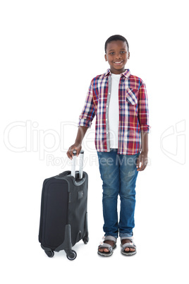 Portrait of smiling boy standing with suitcase