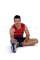 Portrait of sportsman stretching legs while exercising