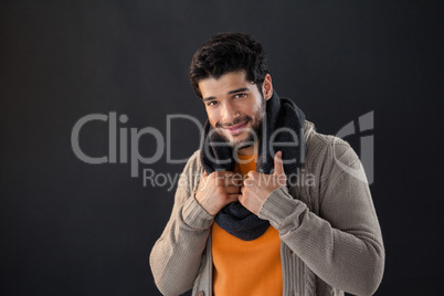 Smiling man posing against black background