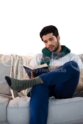 Man sitting on sofa while reading book