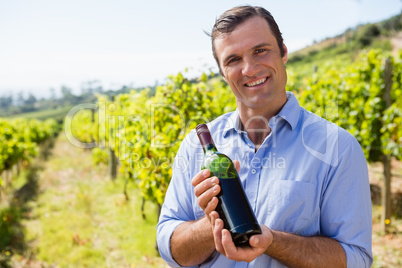 Portrait of smiling vintner examining wine