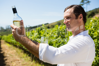 Smiling vintner examining wine