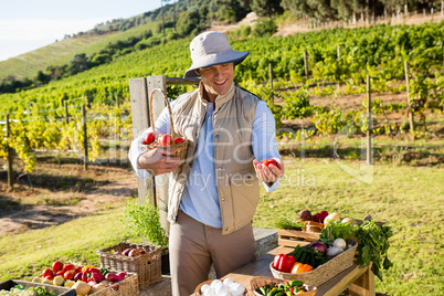 Happy man holding fresh vegetables at stall