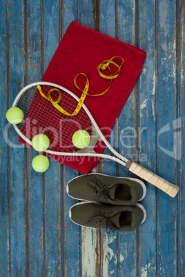 Overhead view of tennis equipment and tape measure on napkin by sports shoes