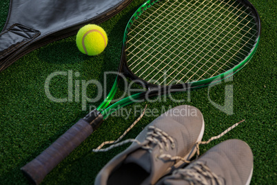 Close up of racket with ball and sports shoes
