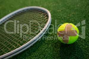 Close up of tennis ball with bandage by racket