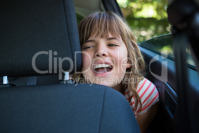 Teenage girl sitting in the back seat of car