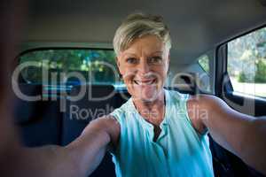 Happy senior woman inside a car