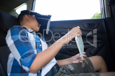 Teenage boy using virtual reality headset with digital tablet