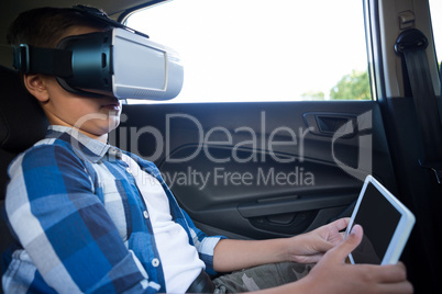 Teenage boy using virtual reality headset with digital tablet