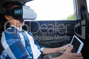 Teenage boy using virtual reality headset with digital tablet