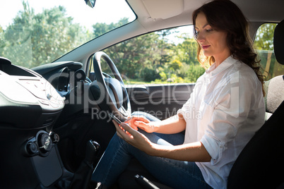 Woman using mobile phone while driving a car