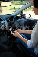 Woman using mobile phone in a car