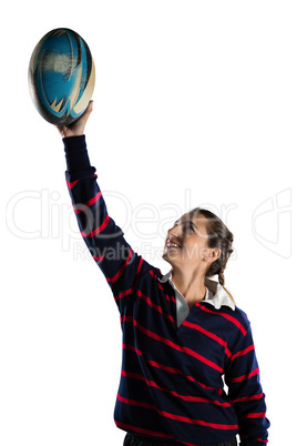 Happy female athlete with arms raised holding rugby ball