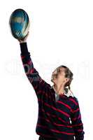 Happy female athlete with arms raised holding rugby ball