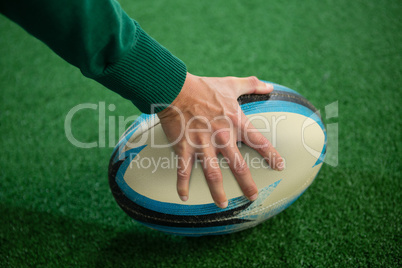 Cropped hand holding rugby ball
