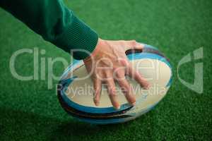 Cropped hand holding rugby ball