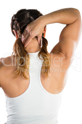 Rear view of female athlete massaging neck