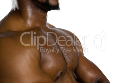 Mid section of shirtless male rugby player with arms crossed