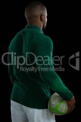 Rear view of male player holding rugby ball