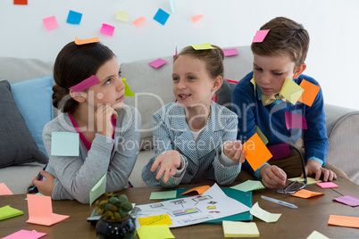 Kids as business executives playing with sticky notes