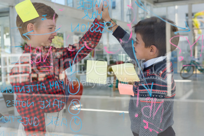 Kids as business executives giving high five to each other near whiteboard