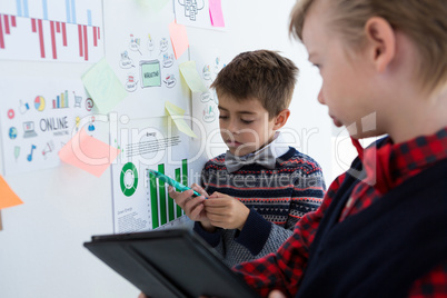 Kids as business executives discussing over whiteboard