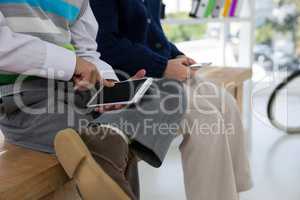 Kids as business executives using smartphone while sitting on table