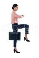 Female executive checking time on white background