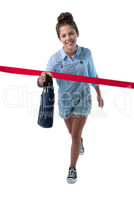 Teenage girl crossing finishing line with bag